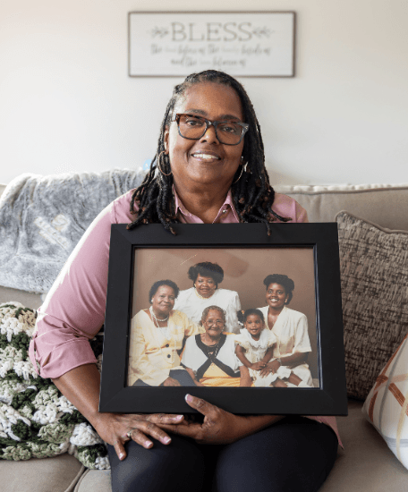 Theresa holds a family portrait in the living room of her new construction home from Oakwood homes.