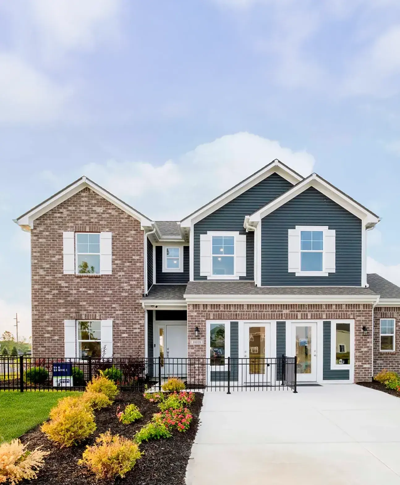 Two story site built home exterior by Arbor Homes by Clayton with brick and blue siding.